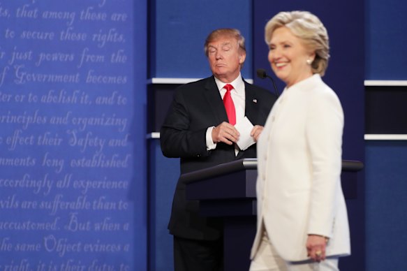 Democratic presidential nominee Hillary Clinton walks off stage as Donald Trump looks on after a campaign debate in 2016.