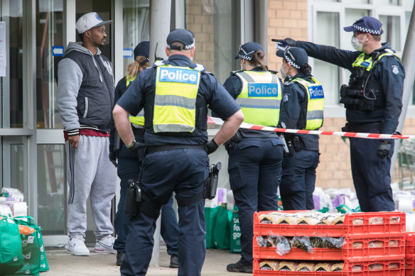 Police and residents outside one of the North Melbourne towers in July 2020.