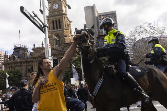 A man punches a police horse during an anti-lockdown rally in Sydney’s CBD.