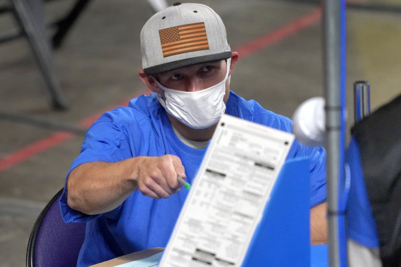 Maricopa County ballots cast in the 2020 general election are examined and recounted by contractors in Phoenix. 
