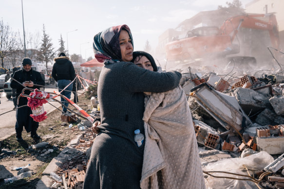 Women embrace as rescue workers search through the rubble in Adiyaman, Turkey, on February 8.