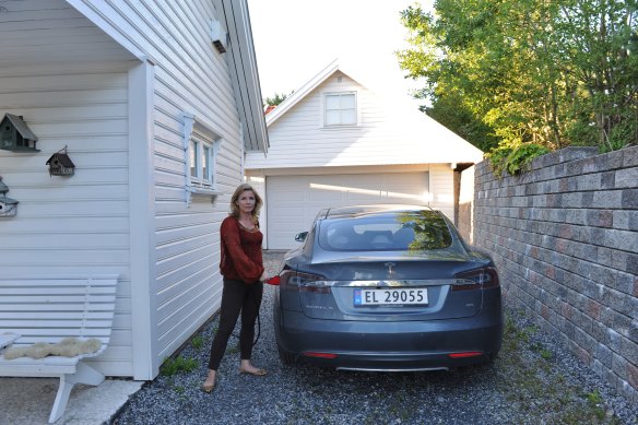Norwegians have the highest uptake of EVs. Here, a resident charges her Tesla electric car.