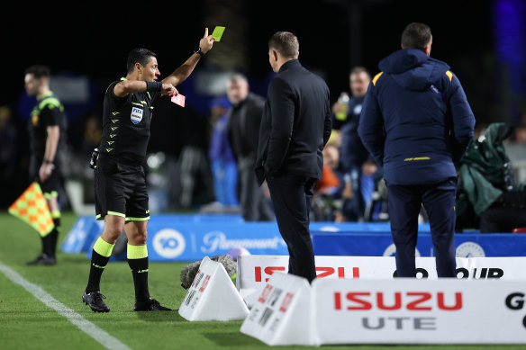 Referee Alireza Faghani shows  Mariners assistant coach Danny Schofield a red card.