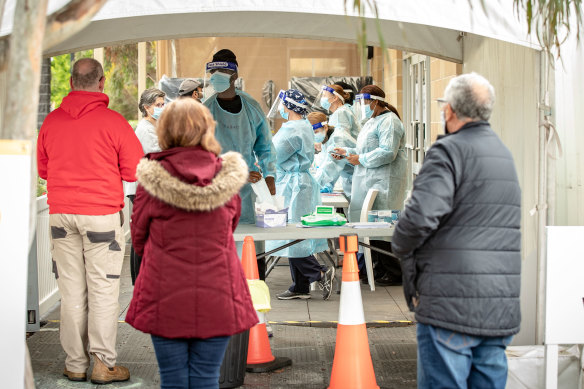 People queue to be tested for COVID-19 at a pop-up clinic in Heidelberg West on Sunday.