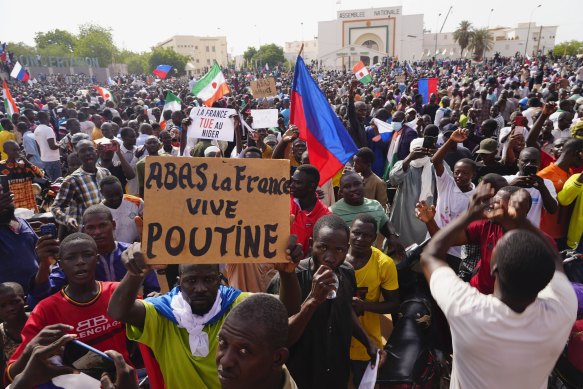 Nigeriens participate in a march called by supporters of coup leader General Abdourahmane Tchiani in Niamey, Niger. The sign reads: “Down with France, long live Putin”.