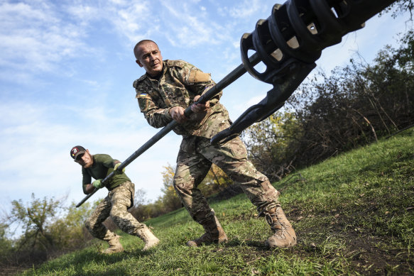 Ukrainian soldiers clean the muzzle of Ukrainian howitzer D-30 near Siversk, Donetsk region, Ukraine.