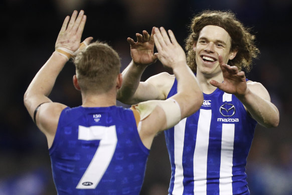 Ben Brown of the Kangaroos (right) celebrates one of his 10 (yes,10) goals in North's drubbing of Port Adelaide.