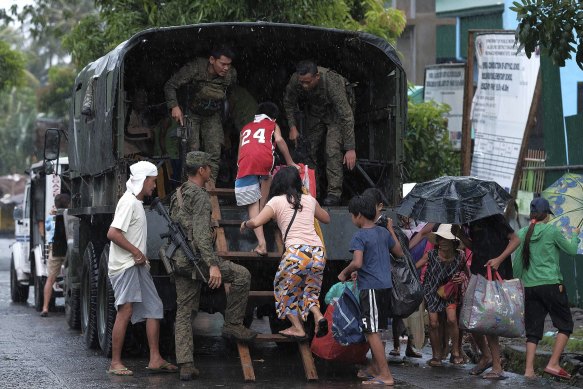 Residents in south-east Manila evacuate in a military truck before the typhoon hits.