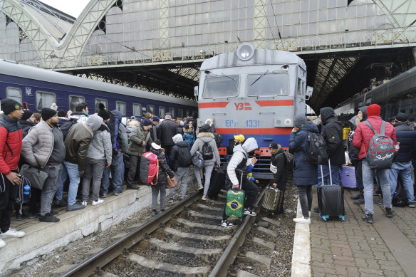 People gather to catch a train and leave Ukraine at the Lviv railway station.