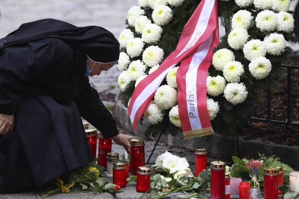 A nun lights a candle at the scene of Monday's terror attack in central Vienna.