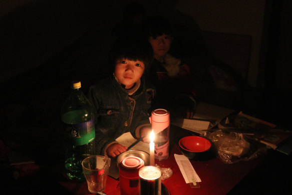 A child of a migrant worker studies under candlelight in Beijing. 