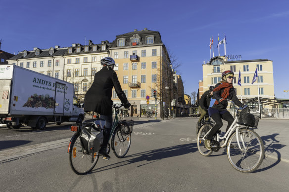 People cycle on bike paths in Stockholm, Sweden.