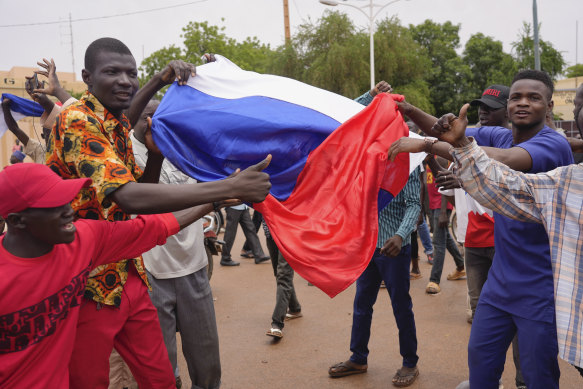 Supporters of mutinous soldiers hold a Russian flag.