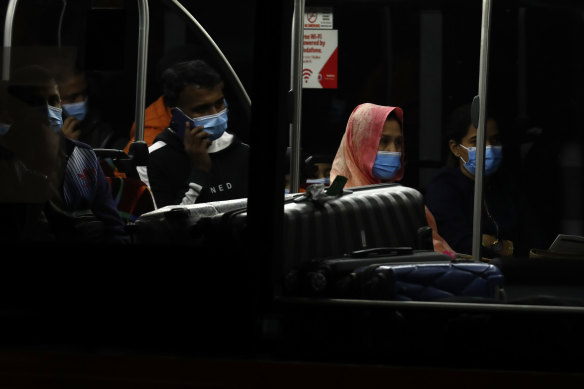 Returning travelers catch the Skybus to hotel quarantine after their repatriation flight from India landed in Melbourne on Thursday evening.