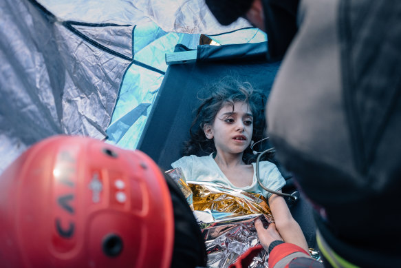 Rescue workers provide first aid to a child they rescued from under the rubble in Adiyaman.