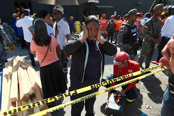 A woman stands outside the Jet Set nightclub after its roof collapsed during a concert.