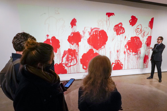 A curator (right) talks about Cy Twombly’s “Untitled”.