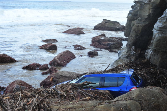 A car on the rocks in Stanwell Park after being washed away in torrential rain and flash flooding.