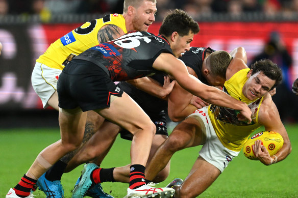 Daniel Rioli is tackled by Essendon’s Jake Stringer.