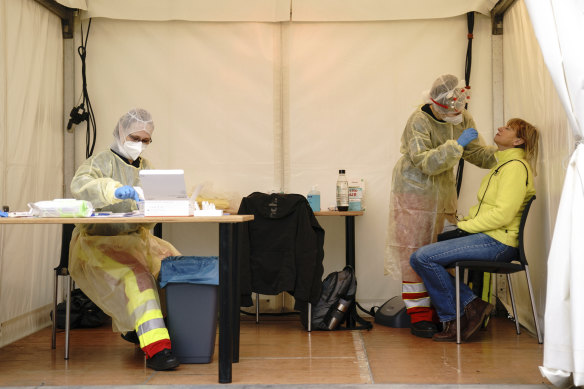 A woman is tested for COVID-19 in a mobile testing site in Berlin, Germany this week.