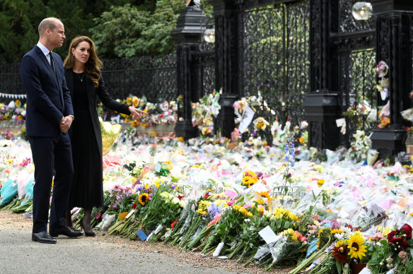 Prince William and Catherine, the Princess of Wales, inspect the flowers left at Sandringham.
