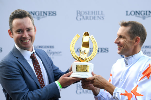Hugh Bowman holds the Golden Slipper trophy with co-trainer Adrian Bott after Farnan's win on Saturday