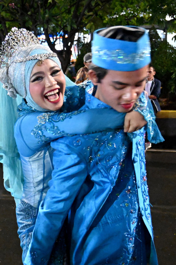 A couple poses for photos as they join hundreds of other couples at a mass wedding event in Jakarta.