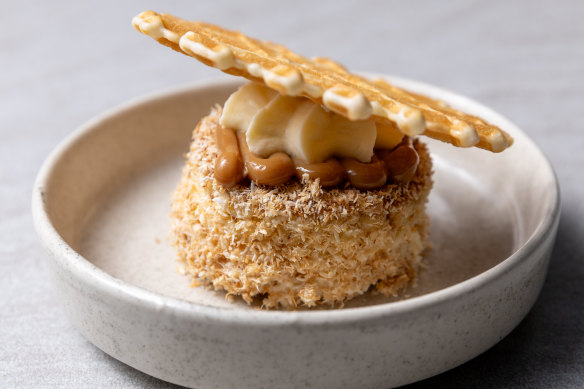 Coconut sponge with coconut diplomat cream and dulce de leche wears an oblea (wafer) mortar board.