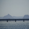 The Bribie Island Bridge, with the Glasshouse Mountains in the background, is set to be duplicated by the state government.