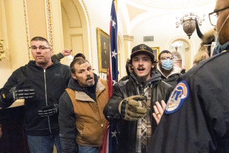 Putin accused the US of “double standards” for prosecuting the rioters, pictured here on January 6 outside the Senate chamber. 