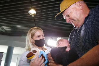 Col greets his daughter, Lauren, and meets his grandson, Ted, for the first time at Brisbane Airport on Tuesday.