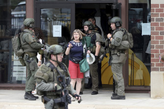 Law enforcement officers help evacuate people after the shooting.