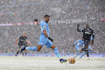 Riyad Mahrez shoots for Manchester City during their snow-affected game against West Ham on Sunday.