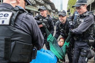 An Extinction Rebellion protester is stopped by police on Thursday.