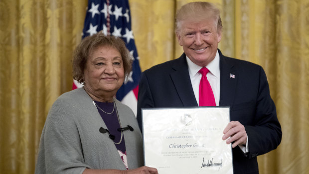 US President Donald Trump presents a Certificate of Commendation to Minnie Grant, the mother of Christopher Grant, one of five civilians celebrated for their heroism during a mass shooting in El Paso.  Grant was stopped by Secret Service from attending.