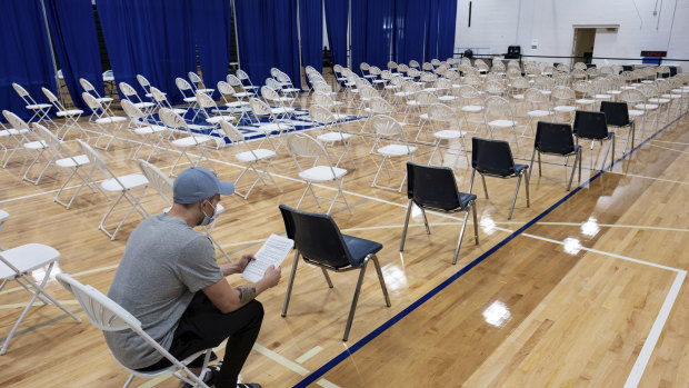 A man sits and waits after getting his first COVID-19 vaccine shot on the last day of the mass vaccination site at the University of North Georgia, Gainesville campus.