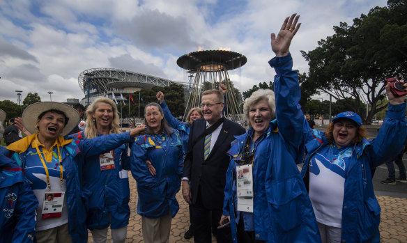 John Coates with Sydney 2000 volunteers at the re-lighting of the Olympic cauldron on Tuesday.