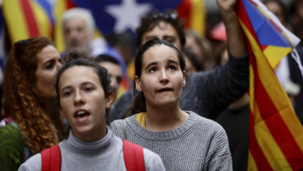 People holding Estelada pro Catalonia independence flags shout slogans during a protest in front of the Spanish embassy in Brussels.