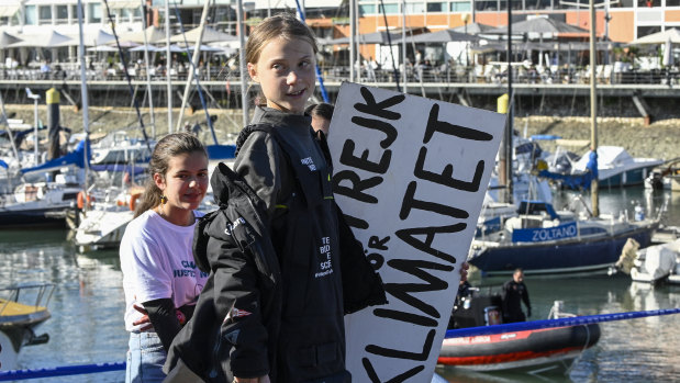 Swedish teen climate activist Greta Thunberg carries the placard "School strike for the climate" which she held outside the Swedish parliament, upon her arrival in Santo Amaro Recreation dock in Lisbon.