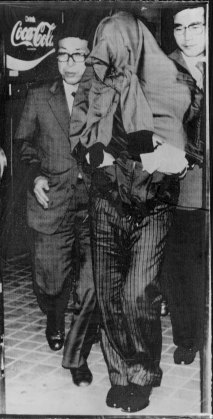 Soviet defector Viktor Ivanovich Belenko is taken away by police after arriving in Tokyo, 1976.