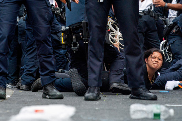 Police officers detain a person at the “giveaway” where police officers responded, dispersing the crowd at Union Square.