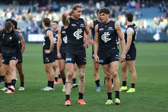 Disapointed Carlton players Tom De Koning and Charlie Curnow walk from the ground.
