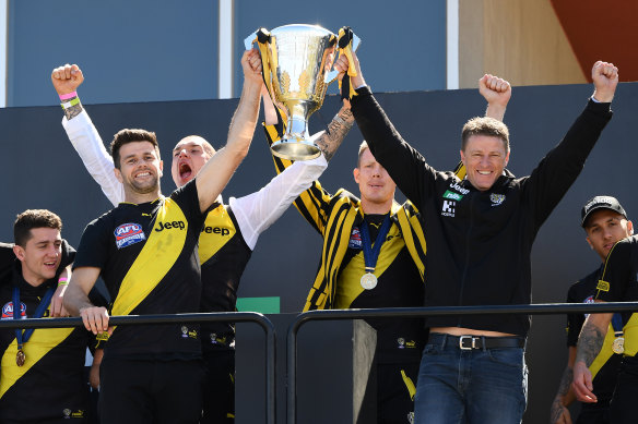 Trent Cotchin and Damien Hardwick lift the 2019 premiership cup with Dustin Martin and Jack Riewoldt behind.