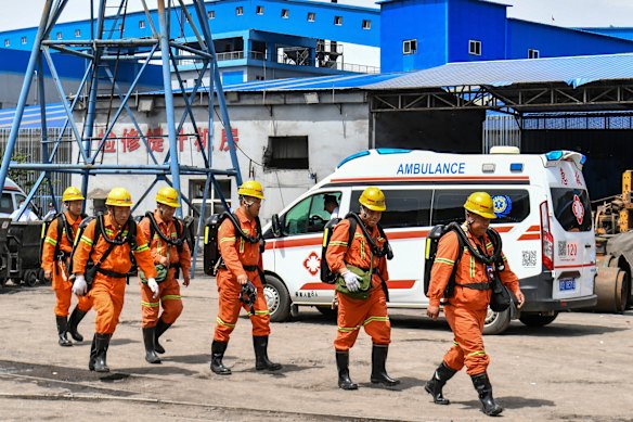 Equipes de resgate passam por uma ambulância a caminho do local do desastre na mina.