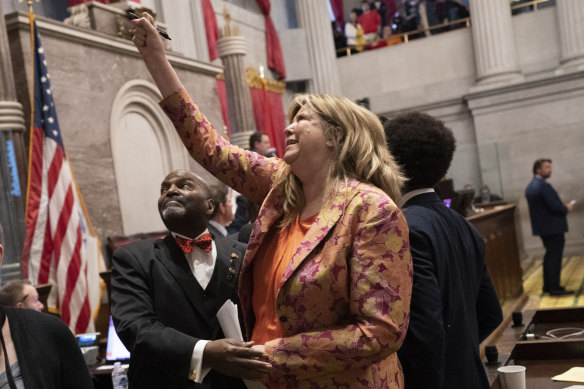 Representative Gloria Johnson raises her fist after a resolution to expel Johnson from the legislature failed on the floor of the House chamber in Nashville.