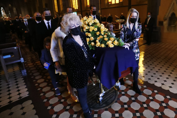 Patti and Lauren Newton lead Bert Newton’s casket out of St Patrick’s Cathedral on Friday. 