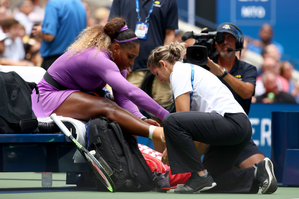 Serena Williams receives treatment after rolling her ankle.