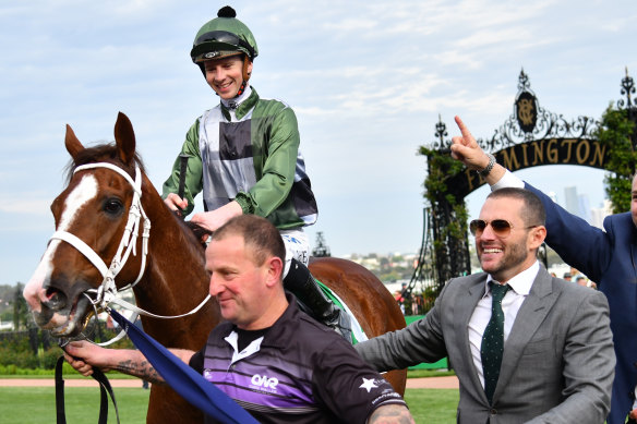 Jockey Jye McNeil returns to scale after riding Kings Will Dream to victory in the Turnbull Stakes at Flemington with part-owner Brae Sokolski in grey suit.