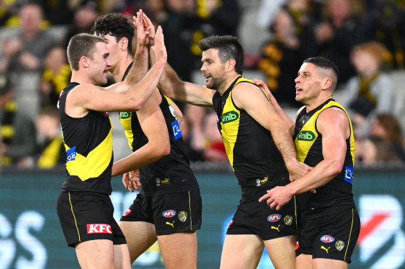 Trent Cotchin of the Tigers is congratulated by teammates after kicking a goal.