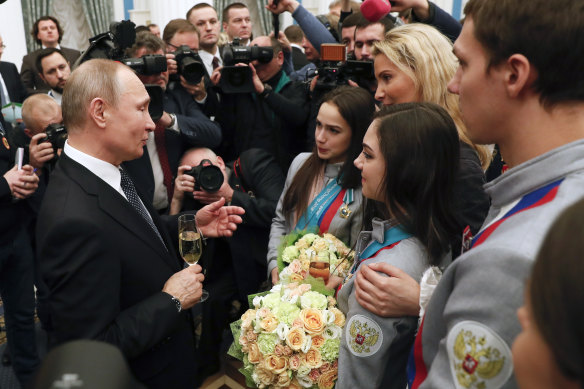 Russian President Vladimir Putin speaks to Alina Zagitova, Evgenia Medvedeva and Tutberidze after the skater won gold and silver at the 2018 Games.